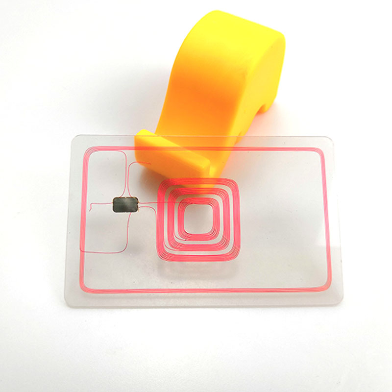 Прозрачна PVC карта с червена RFID антенна намотка и чип модул, показващи вътрешната структура на RFID блокиращата карта.
