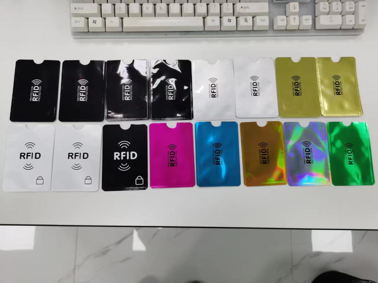 Различни RFID блокиращи калъфи са подредени под клавиатура за сравнение на гланцови, матови и металически повърхности.