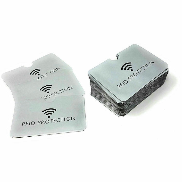 Комплект от сребърни RFID блокиращи калъфи върху бял фон показващ отвора за палеца за лесно изваждане на картата.
