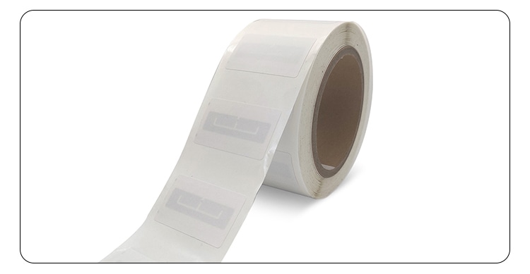 Чиста продуктова снимка показва ролка празни RFID етикети с частично развита лента върху бял фон.
