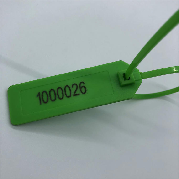 Близък детайл показва отпечатан сериен номер върху зелен RFID кабелен таг, със заключваща глава и контур на лентата до етикетния панел.