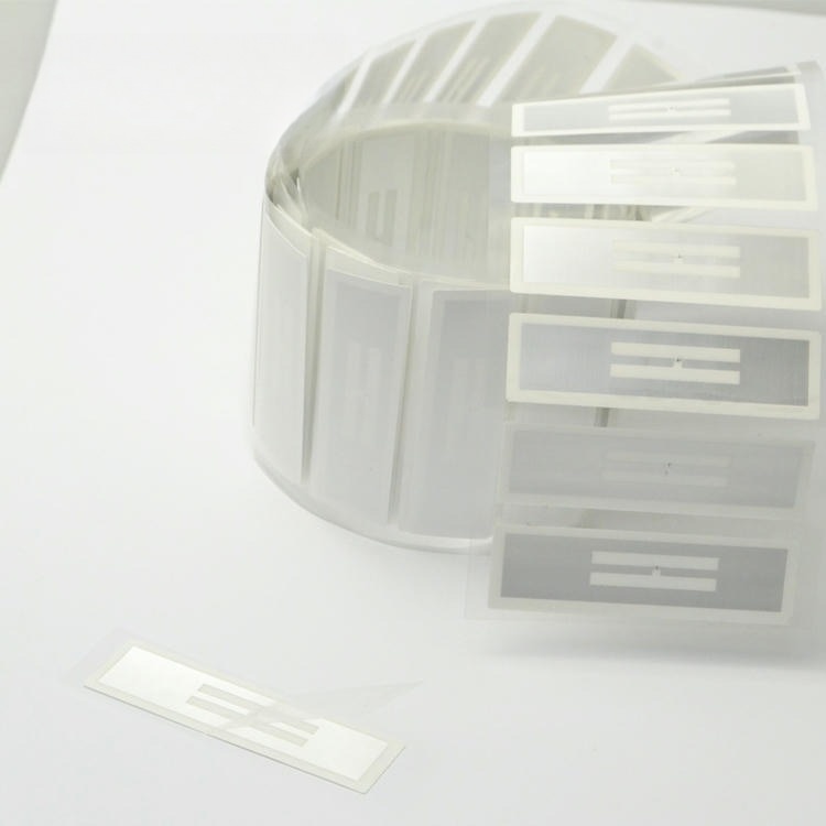 Близък продуктов план показва прозрачни RFID инлей етикети до основното руло за да подчертае вътрешния антенен модел.