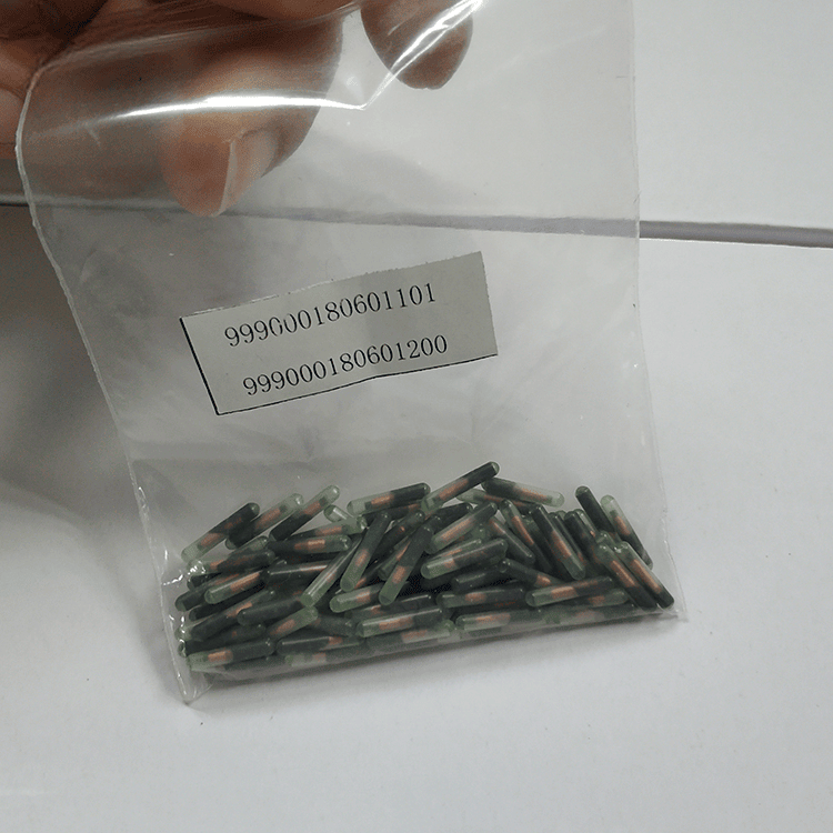 Голяма опаковка с RFID микрочипове за животни върху маса с отпечатан етикет с номер за организирана наличност при програми за идентификация.