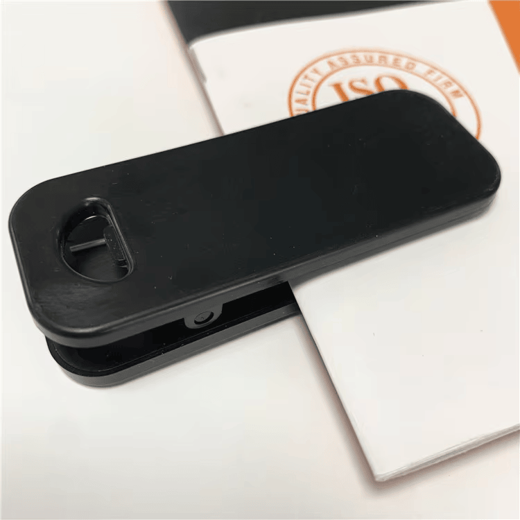 Изображението показва RFID клипс тага SV-015 закачен към хартиен лист за да демонстрира употребата за проследяване на активи или документи.