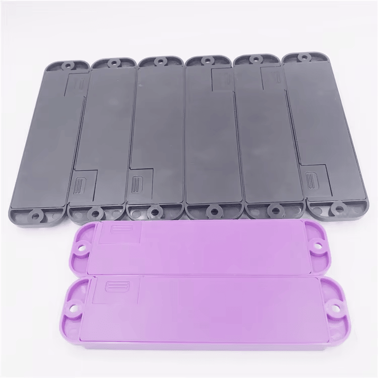 Два лилави RFID тага със звук и LED ABS13634-1 поставени пред няколко сиви тага на светъл фон.