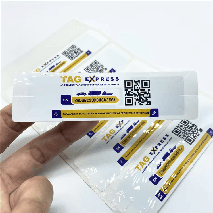 Пръст посочва единичен UHF RFID стикер за предно стъкло с печат TAG EXPRESS, QR код и зона за сериен номер.