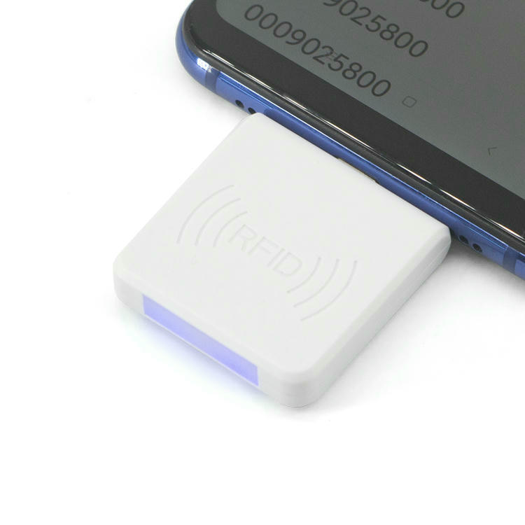 Изображението показва белия мобилен UHF RFID четец R65H свързан към смартфон чрез Type C интерфейса.